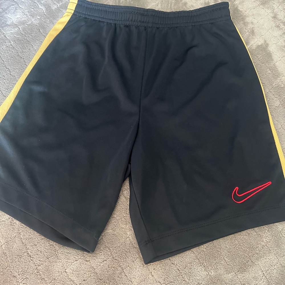 Boys Nike medium black shorts with gold stripe on side. NWOT. Never worn